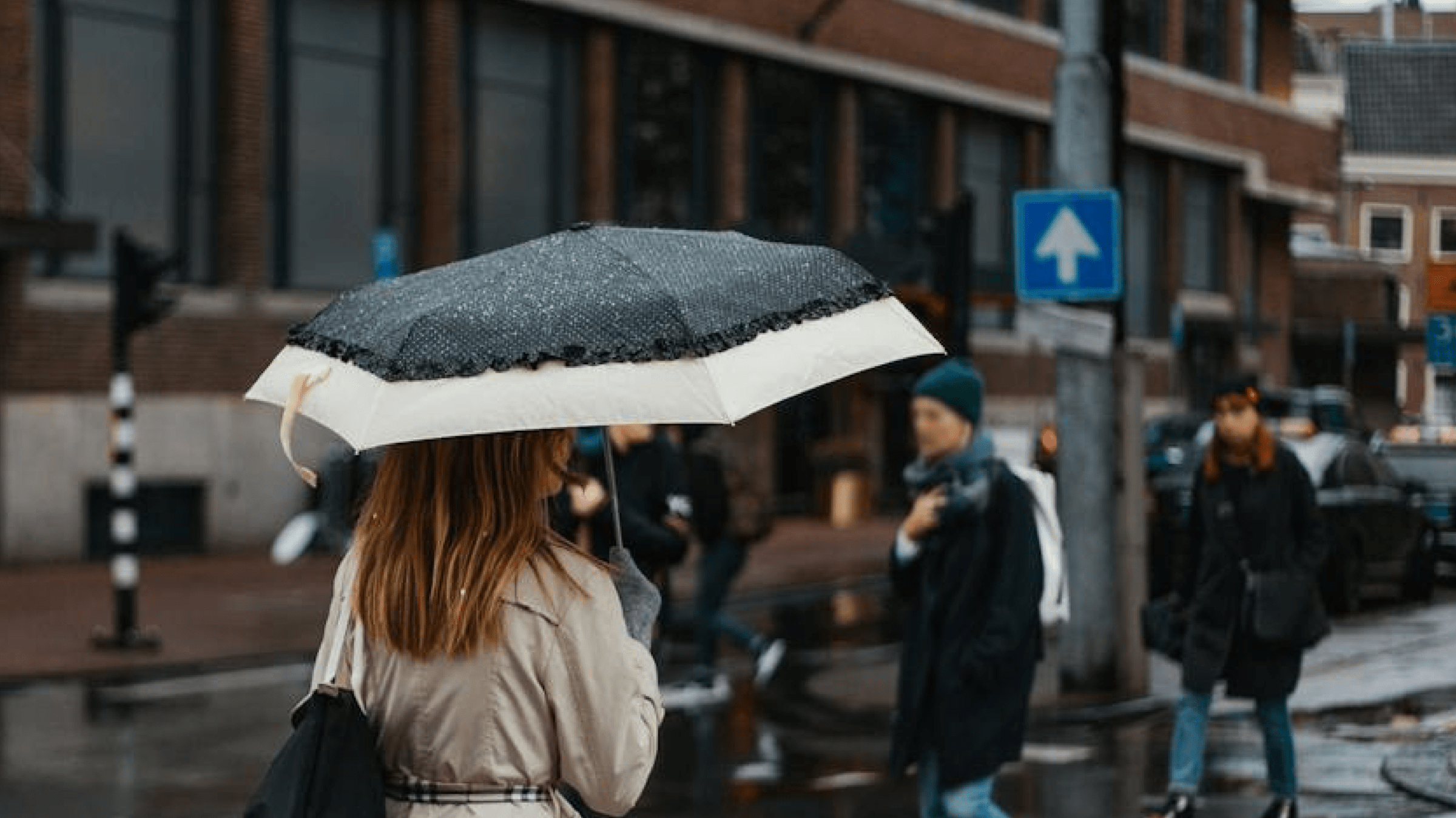 Vrouw in Amsterdam met regenwater op paraplu. Bron: Pexels (Max Avans)