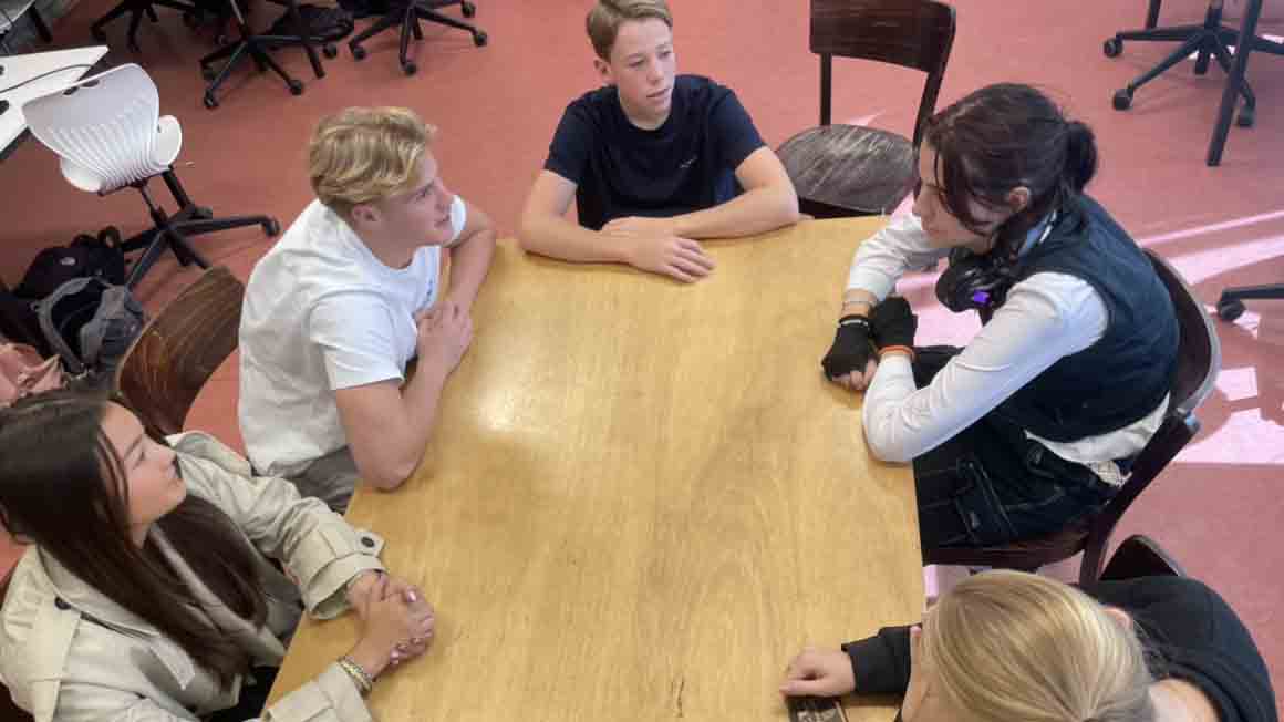 studenten rond een tafel in een gesprek