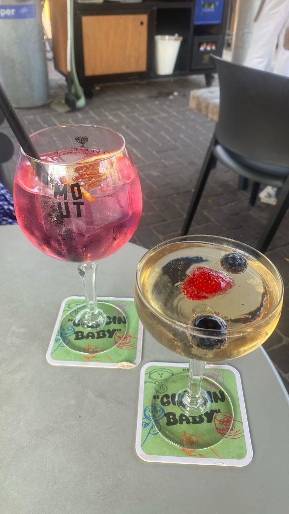 2 drankjes op tafel op een terras mensen kijken
